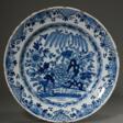 Delfter Fayence Teller mit Blaumalerei nach chinesischem Vorbild „Blumengarten“ und floral ornamentiertem Rand, De Lampetkaan, 18.Jh., Ø 34,8cm, Rand best., Provenienz: Slg. Hermann Delker, Hamburg, danach Hamburger Priv… - Auktionspreise