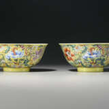 TWO RARE AND SUPERBLY DECORATED FAMILLE ROSE YELLOW-GROUND BOWLS - Foto 2