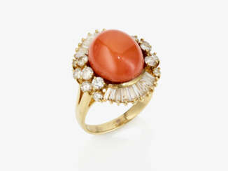 An entourage-like cocktail ring decorated with a coral in the "Saciacca" tone, brilliant-cut diamonds and trapeze-cut diamonds