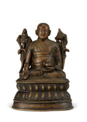 A SILVER-INLAID BRONZE FIGURE OF A LAMA