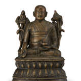 A SILVER-INLAID BRONZE FIGURE OF A LAMA - photo 1