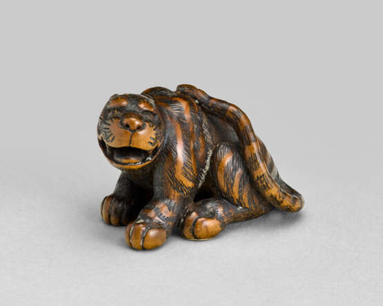 A CARVED WOOD NETSUKE OF A TIGER - фото 1