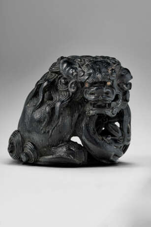 A CARVED WOOD NETSUKE OF A SHISHI HOLDING A BALL - фото 1