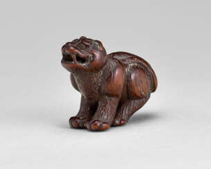 A CARVED WOOD NETSUKE OF TIGER