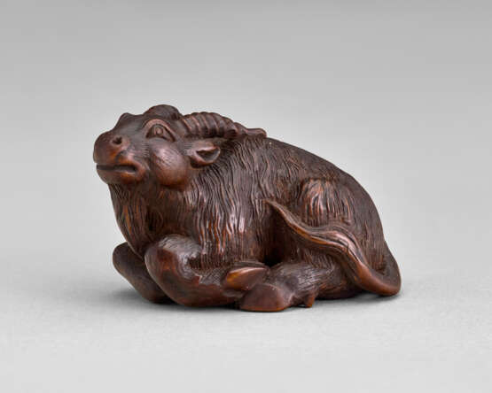 A CARVED WOOD NETSUKE OF A GOAT - фото 1