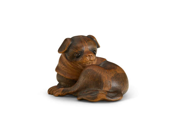 A CARVED WOOD NETSUKE OF A RECUMBENT DOG - Foto 1