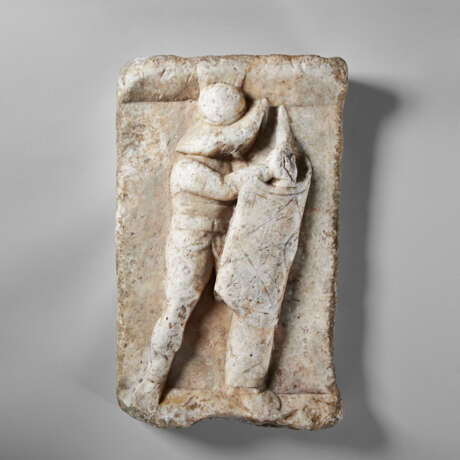 A ROMAN MARBLE RELIEF WITH A MURMILLO GLADIATOR - Foto 1