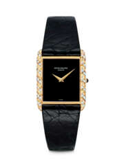 PATEK PHILIPPE. A LADY’S ELEGANT 18K GOLD AND DIAMOND-SET WRISTWATCH WITH ONYX DIAL