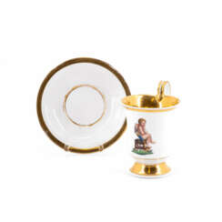 KPM. Tasse und Untertasse mit grübelndem AmorKPM. PORCELAIN CUP AND SAUCER WITH BROODING CUPID