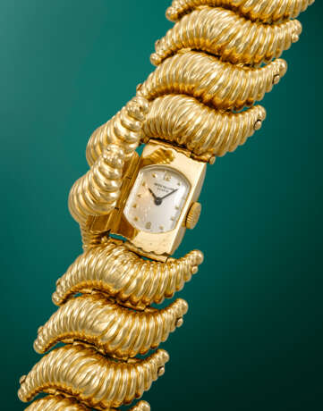 PATEK PHILIPPE. AN UNUSUAL AND HIGHLY ATTRACTIVE 18K GOLD SHELLS SHAPE BRACELET WATCH WITH CONCEALED DIAL - фото 2