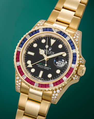 ROLEX. A RARE AND DAZZLING 18K GOLD, DIAMOND, RUBY AND SAPPHIRE-SET AUTOMATIC DUAL TIME WRISTWATCH WITH SWEEP CENTRE SECONDS, DATE AND BRACELET - photo 2