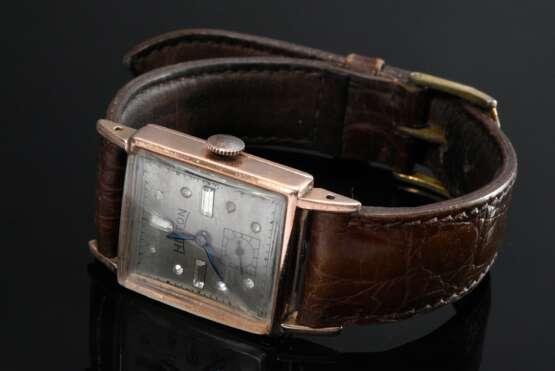 Rotgold 585 Armbanduhr "Hilton Watch", Handaufzug, weiße Imitatsteine, gebläute Zeiger, kleine Sekunde, Minuten Indizes, braunes Lederarmband mit vergoldeter Dornschließe, um 1940, 3,6x2,1cm, gangbar (keine Gar… - photo 1