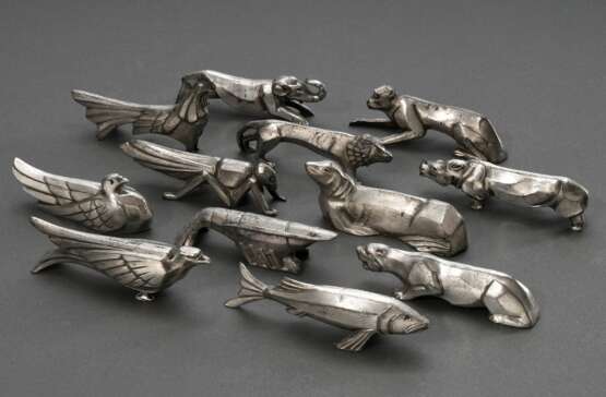 12 Art Deco Messerbänkchen in abstrahierten Tierformen, Metall versilbert, Frankreich um 1920: Affe, Tiger, Lachs, Heuschrecke, Adler, Hahn, Löwe, Elefant, Seelöwe, Taube, Nashorn und Hummer, L. 7,7-10,5cm - фото 1