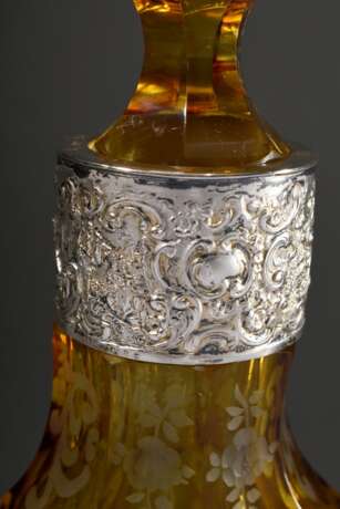 Hexagonal konische Glas Karaffe mit gelbem Überfang und floralem Schliff "Blumenkörbe und Füllhörner" sowie ornamentierter Silber Manschette "Spielende Putten" am Hals, 1. Hälfte 20.Jh., H. 29,2cm… - photo 3