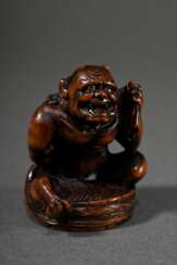 Buchsbaum Netsuke &quot;Oni im Waschzuber&quot; mit eingelegten Horn Augen, muskulöse Darstellung mit freundlichem Gesichtsausdruck, sign. Kokushie in ovaler Reserve, verschieden große Himotoshi, schöne Patina, H. 3,8cm,…