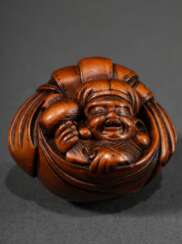 Kompaktes Buchsbaum Netsuke &quot;Daikoku in seinem Sack verschnürt sitzend&quot;, schöner Faltenwurf, funktional geschnitzte Himotoshi verhindern das Kippen des Netsuke, 19.Jh., H. 3,4cm, Provenienz: Norddeutsche Sammlu…