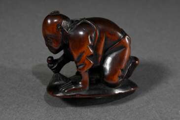 Kleines Buchsbaum Netsuke &quot;Herzpolierer&quot;, Mann poliert das Kanji Kokoro (Herz), Darstellung illustriert den Ausspruch &quot;Kokoro o migaku&quot; als Aussage für &quot;Sich bessern&quot;, 19.Jh., H. 2,8cm, Vgl.…