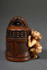 Feines antikes Buchsbaum und Hirschhorn Netsuke &quot;Oni auf eine Tempelglocke steigend&quot;, auf Hirschhorn Kartusche sign. Zeraku 是樂, Himotoshi mit Silber eingefasst, 18./19.Jh., H. 4,8cm, Provenienz: Norddeutsche Sa…