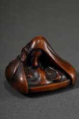 Buchsbaum Shunga Netsuke mit in Tuch gehüllter Tengu Maske, als erotische Anspielung wie auch als Darstellung des Fuji lesbar, Faltung am Boden wiederholt das Fuji Motiv, 19.Jh., schöne Patina, L. 4,4cm, Vgl.: Collection…