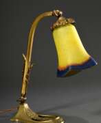 Übersicht. Jugendstil Tischlampe mit justierbarem Messing Gestell und glockenförmigen Glasschirm mit gelb-orange-blauen Einschmelzungen, H. 33,4cm