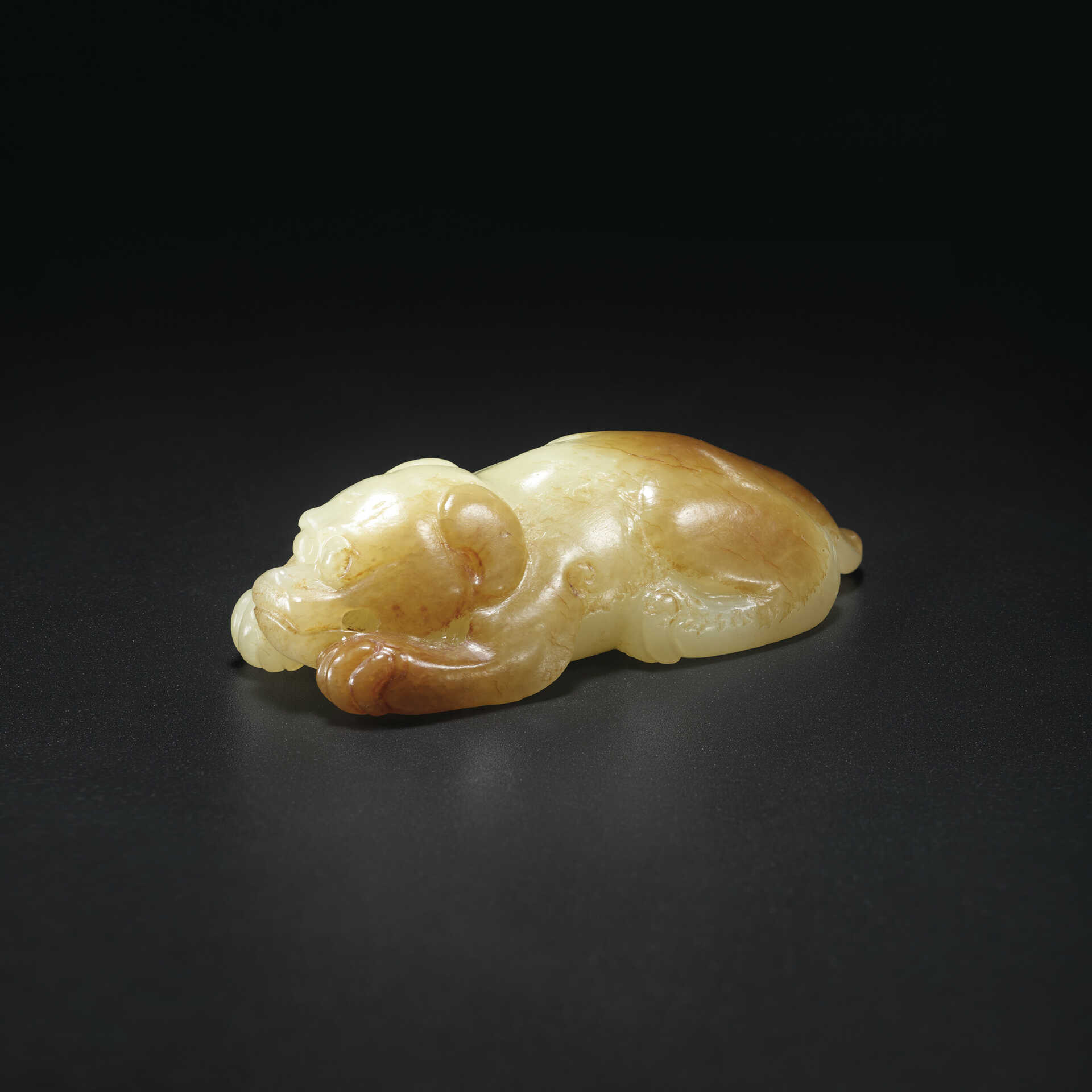 A YELLOW AND RUSSET JADE RECUMBENT HOUND