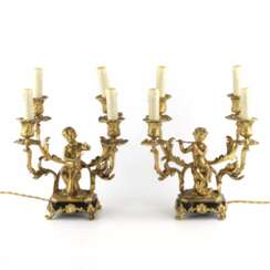 Paired lamps of gilded bronze with cupids playing music.