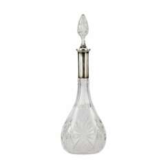 Crystal decanter with a silver neck.