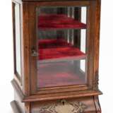 Modellvitrine, um 1900, mahagonifarben, 3-seitig verglast, im Sockel 1 gebauchte Schublade, hinter Tür 3 Einlegeböden, verspiegelte Rückwand, Metallbeschläge (1x fehlt), 31x19,5x17 cm - photo 1