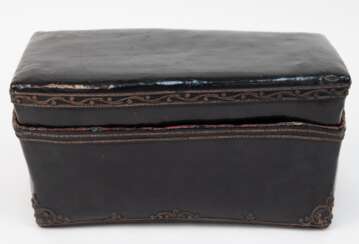 Lackierte Kissenbox, Burma, 18. Jh., Pappmaché, schwarz mit ornamentalen Reliefrändern, innen rot lackiert, Ecken mit Gebrauchspuren, ca. 16,5x31x15 cm