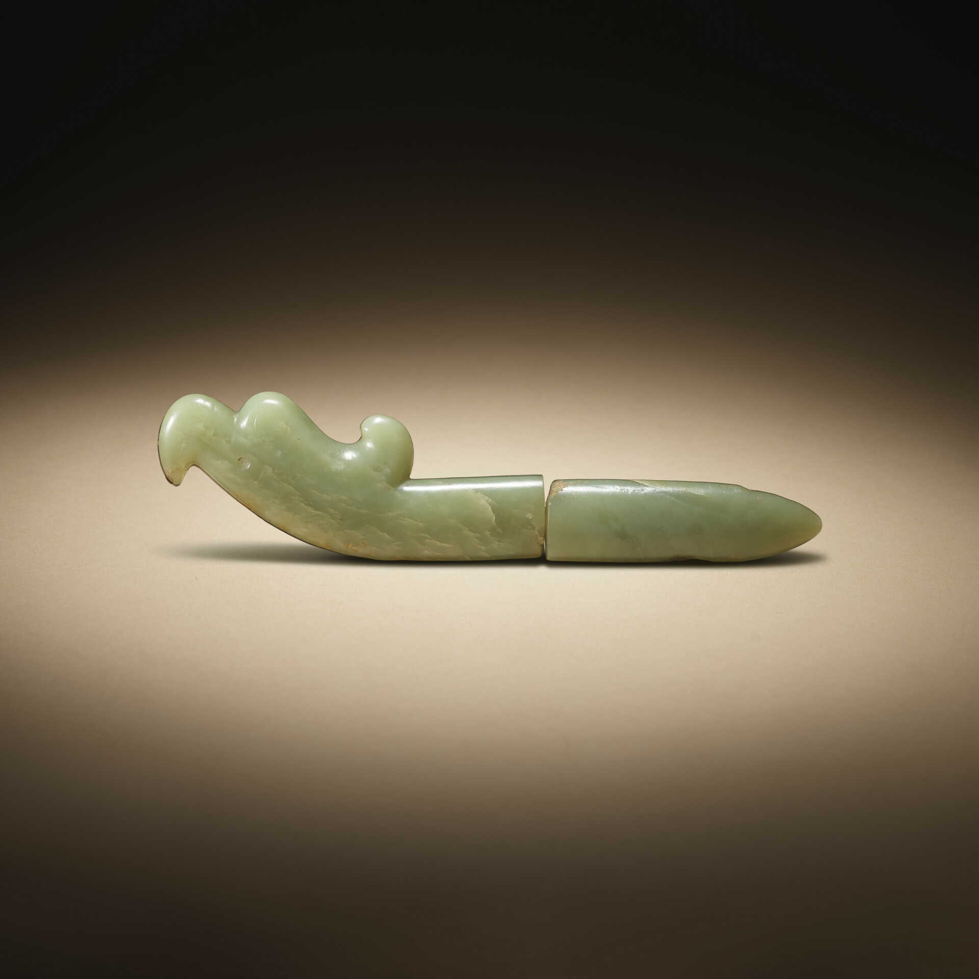 A TWO-SECTIONED CELADON JADE HAWK-HEAD FORM FINIAL