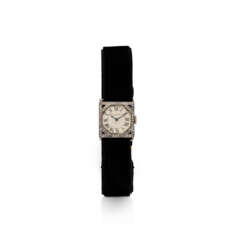 CARTIER EARLY 20TH CENTURY DIAMOND AND ONYX BRACELET-WATCH