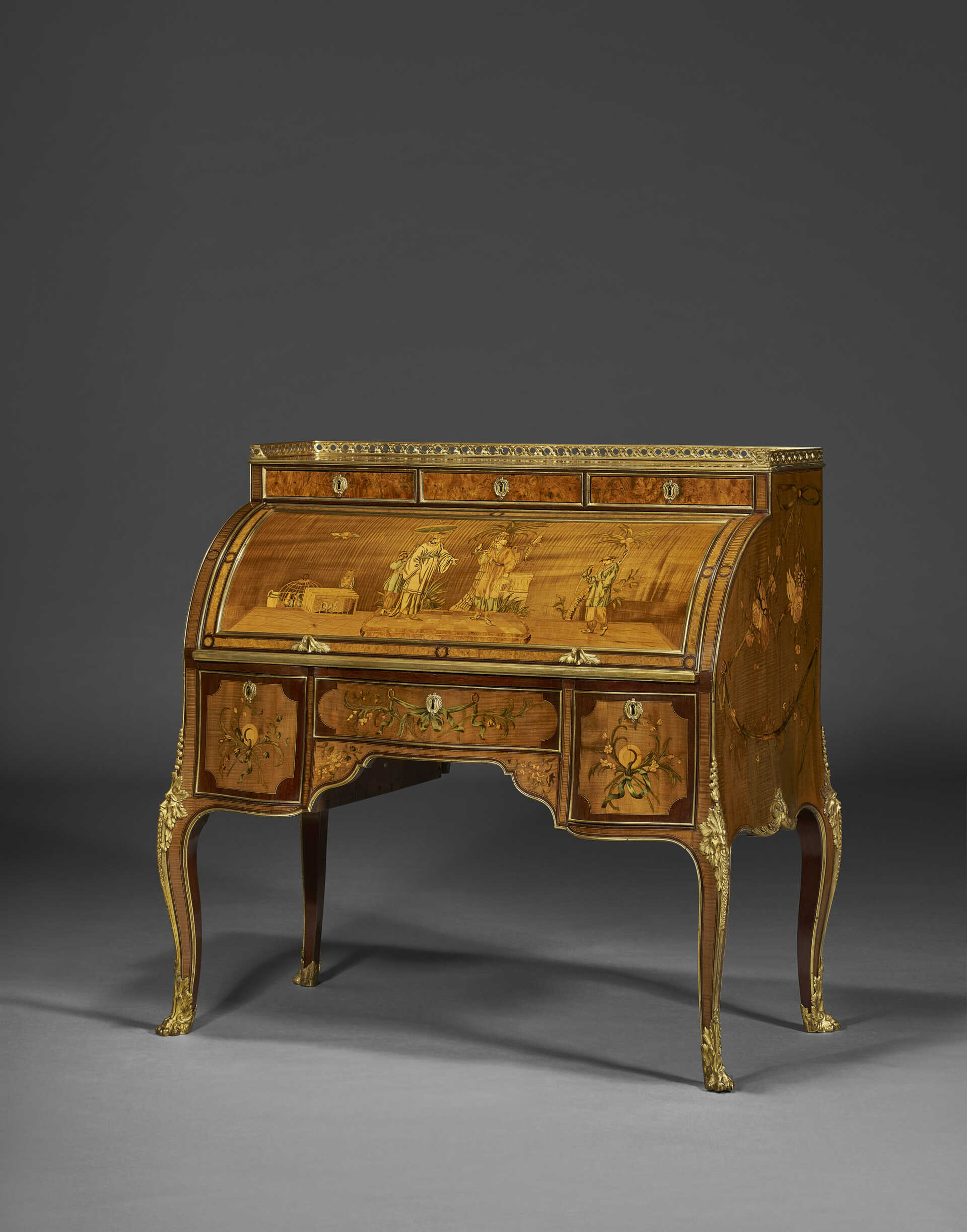 A GERMAN ORMOLU-MOUNTED SYCAMORE, AMARANTH AND MARQUETRY CYLINDER BUREAU