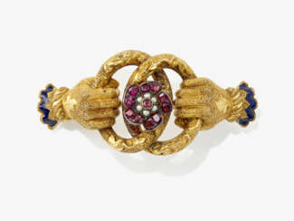 A brooch with two hands with garnets, seed pearls and enamel. Circa 1850