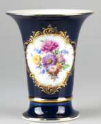 Porcelain products. Meissen-Kratervase, kobaltblauer Fond mit Goldrändern, Schauseite mit polychromem Blumenbukett in goldgerahmtem Medaillon, 1. Wahl, H. 16,5 cm