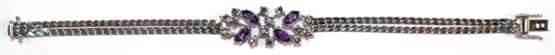 Armband, 585er WG, dekoratives Mittelteil besetzt mit 6 Brillanten von zus. ca. 0,06 ct. und 4 Amethysten im Navetteschliff, Ges.-Gew. 19,58 g, Kastenschloß mit 2 Sichterheitsachten, L. 18,8 cm - photo 1