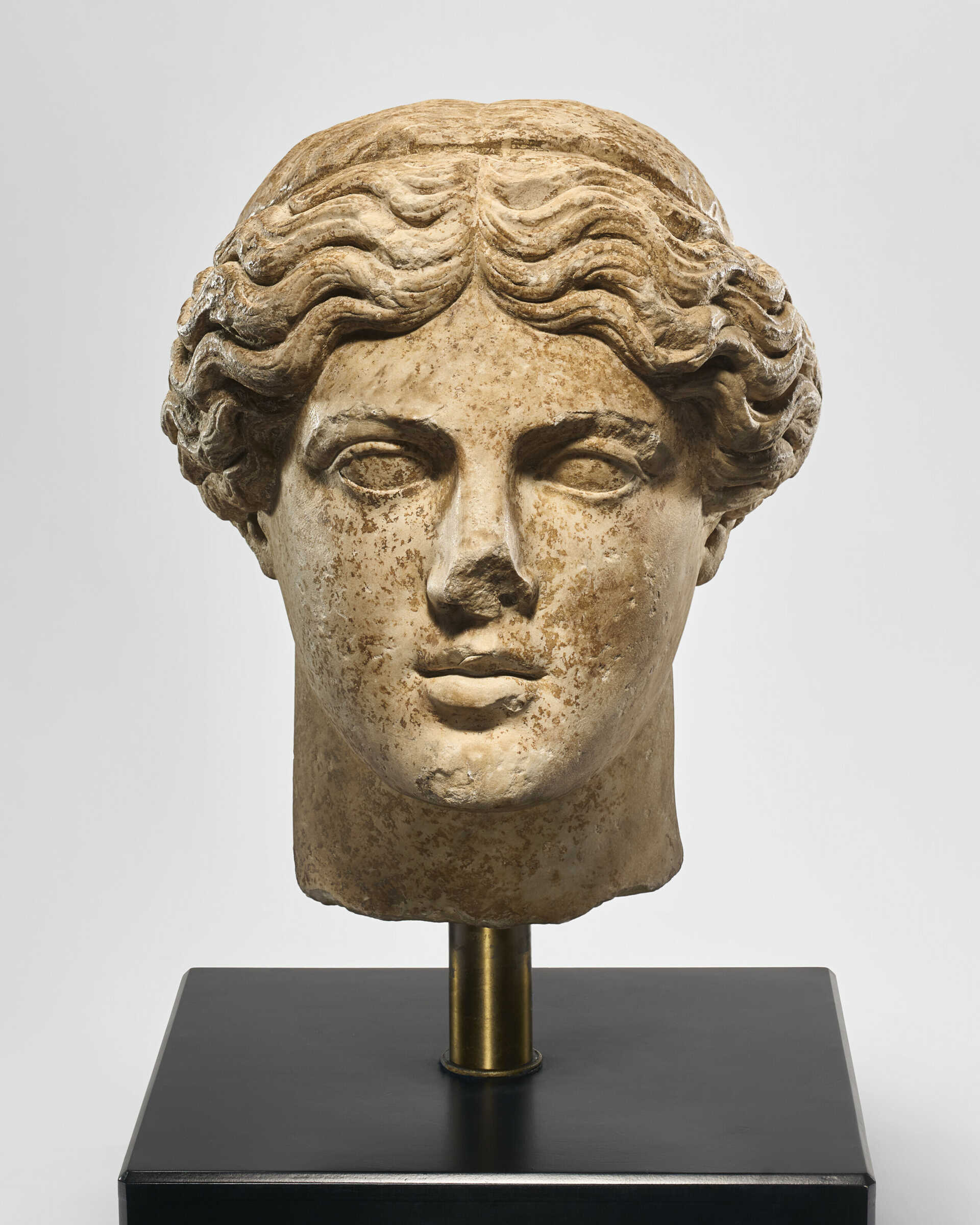 AN OVER-LIFESIZED ROMAN MARBLE HEAD OF APOLLO