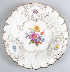 Meissen-Prunkteller, im Spiegel polychromes Blumenbukett, Rand muschel- und rocailleförmig reliefiert mit Goldstaffage und Blumenmalerei, 1. Wahl, Dm. 29,5 cm