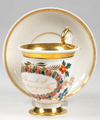 Biedermeier-Tasse mit UT, mit Spruch "Erlebe noch oft den heutigen Tag" in floral gerahmten Medaillon, breite Goldränder z.T. berieben, hochgezogener Volutenhenkel - фото 1