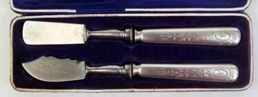 Butter- und Käsemesser, 800er Silber-Griffe datiert 1881, wohl ergänzt, L. 19 cm, im Etui