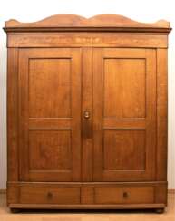 Biedermeier-Kleiderschrank, Eiche z.T. intarsiert, geschweiftes Gesims mit Inschrift &quot;I. Elisabeth Meyn Anno 1846&quot;, 2-türig, im Sockel 2 Schubladen, die innen durch Stifte verriegelbar sind, Zierleisten in Türf…