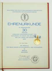 DDR: Medaille für treue Dienste im Gesundheits- und Sozialwesen, in Gold, mit Urkunde für einen Doktor.