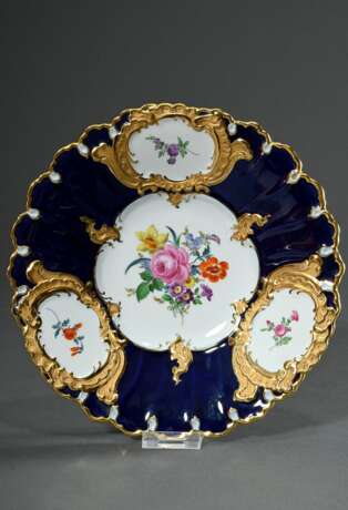 Meissen Prunkteller "Deutsche Blume" mit kobaltblauem Fond und Goldrelief, Porzellan polychrom und goldstaffiert, Modellnr.: F152b, Mitte 20.Jh., Ø 23,5cm, 2 Schleifstriche - photo 1