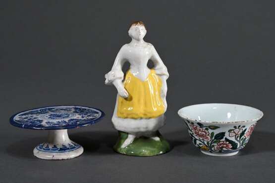 3 Diverse Fayence Miniaturen mit polychromer Scharffeuerfarben Bemalung, Frankreich/Holland 18.Jh.: kleine Figur „Stehende Frau“ (H 11,8cm), Koppchen „Blumen in asiatischer Manier“ (H. 3,6cm) und Tazza mit Blaumalerei (H… - Foto 1