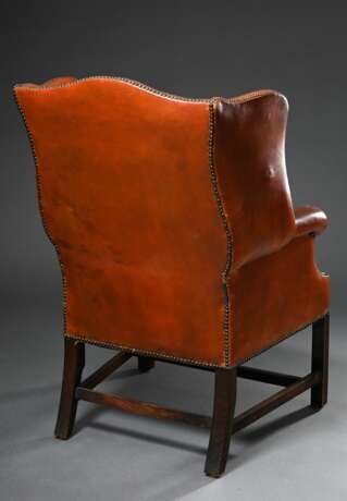 Englischer Ohrensessel, sog. "Grandfather Wingchair" mit rotbraunem Lederpolster und Messingnägeln auf kanneliertem Holzgestell, H. 46/110,5cm, Defekte am Leder - Foto 4