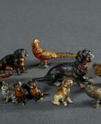 Objets de vertu. 8 Diverse Wiener Bronze Miniaturen, polychrom bemalt: 3 Dackel, 1 Jagdhund, 1 Bär, 1 Pfau, 1 Fasan und 1 Katzengruppe, H. 1,7-2,7cm