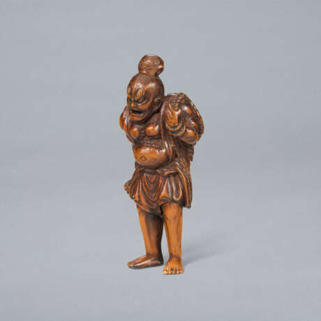 A CARVED WOOD NETSUKE OF A NIO CARRYING ANLARGE STRAW SANDE - photo 1