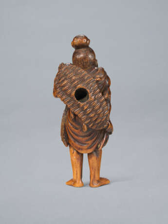 A CARVED WOOD NETSUKE OF A NIO CARRYING ANLARGE STRAW SANDE - photo 3