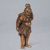 A CARVED WOOD NETSUKE OF A NIO CARRYING ANLARGE STRAW SANDE - photo 4