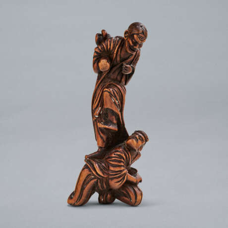 A CARVED WOOD NETSUKE OF ONI STANDING ON WATANABE NO TSUNA - photo 1