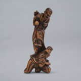 A CARVED WOOD NETSUKE OF ONI STANDING ON WATANABE NO TSUNA - photo 1